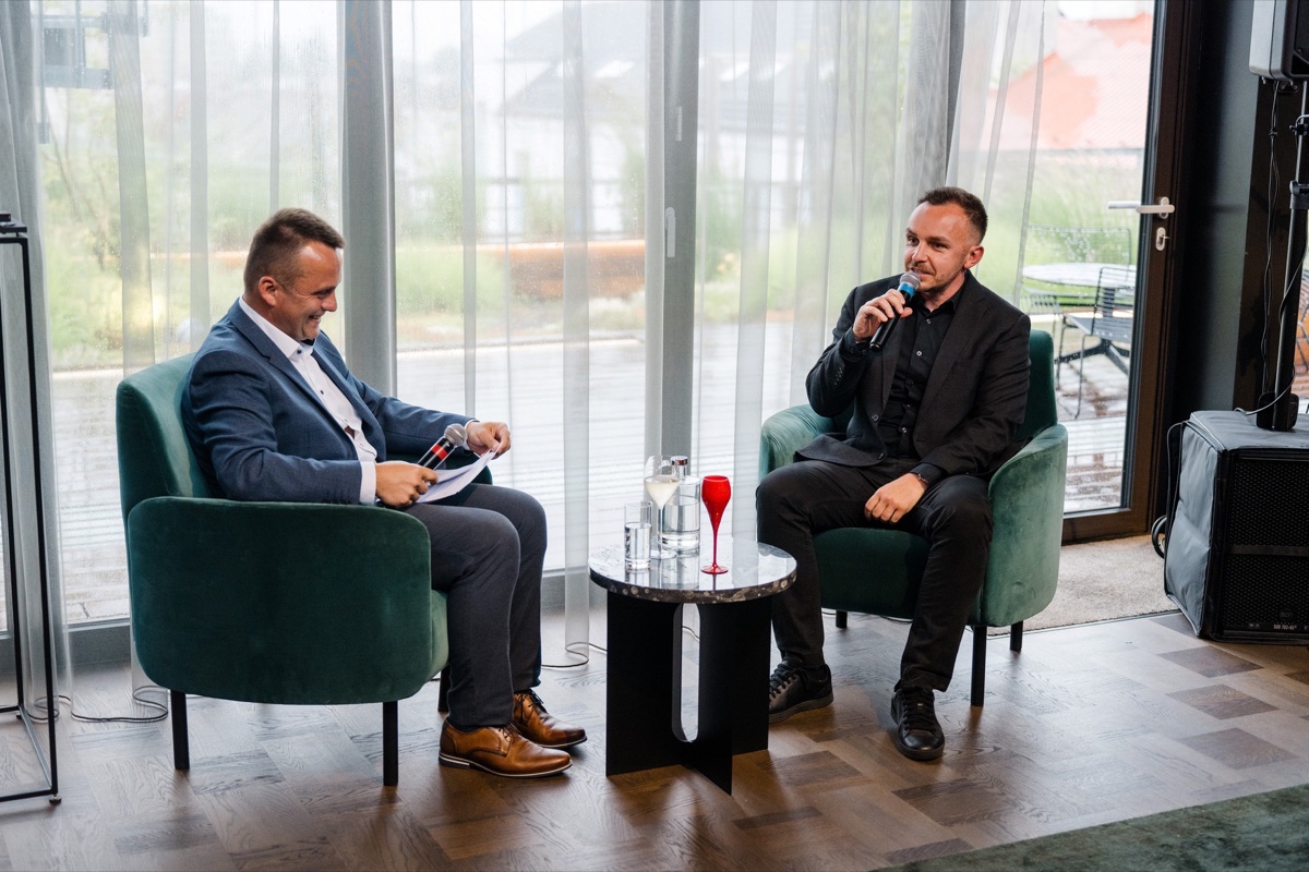 Rozhovor dvou hostů v křeslech u okna
